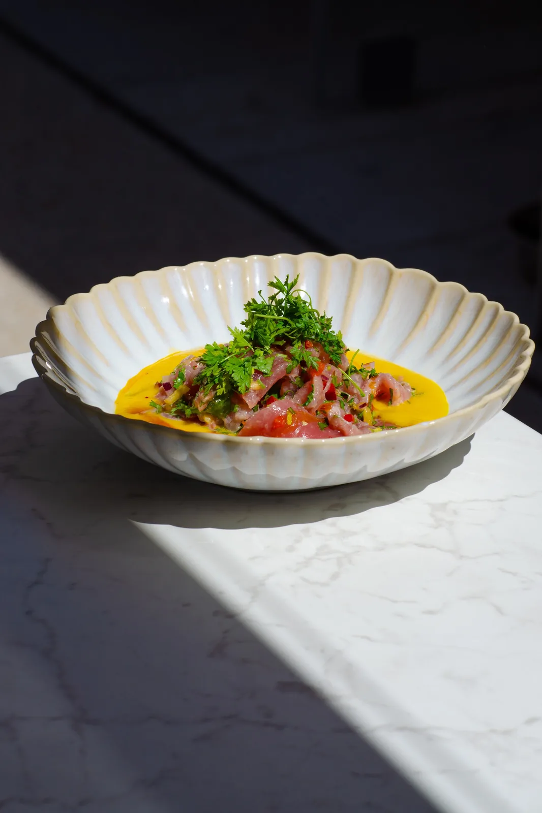 A signature dish at Loma, golden light overlooking Port Canto